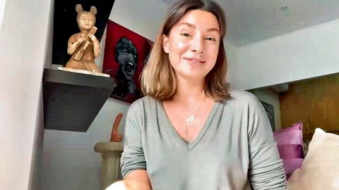 Cute brunette smiling in gray V-neck top for DIY oral explanation video