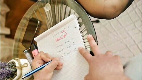 Hand writing notes on notepad in casual indoor setting