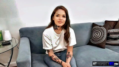 Vanessa Vega in casual white t-shirt and jeans, smiling with tattoos