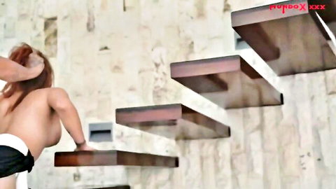 Gorgeous redhead MILF topless climbing stairs in sexy pose