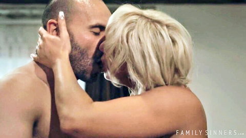 Bald bearded man passionately kisses topless blonde MILF grabbing her head intensely