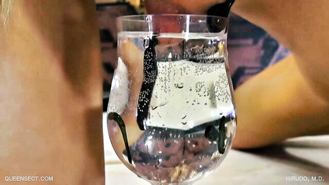 Woman's bare thighs gripping bubbly vanilla water glass while sucking straw intimately