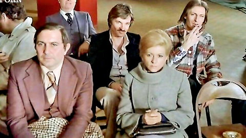 Vintage 70s audience group of suited men and blonde women sitting clothed in theater seats