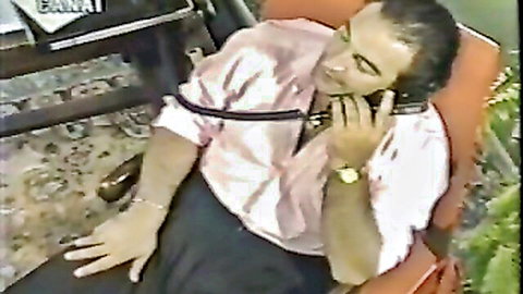Man lounging on chair, talking on phone in classic Canai Film adult scene