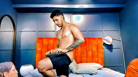 Muscular tanned guy shirtless in black shorts on gay cam