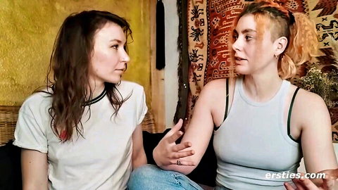 Two wet-haired amateur lesbians in tank tops sitting intimately on couch chatting