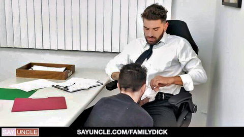 Suited DILF boss gropes young employee's cock bulge over pants on office desk