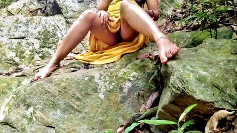 Nepali babe in yellow dress spreads legs flashing shaved pussy on jungle rock