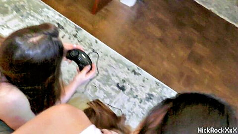 Two busty brunettes playing video games in casual wear, step-sister and friend setup