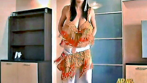 Busty Asian belly dancer with big tits in orange fringed outfit