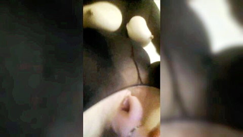 Blurry closeup of white rounded toys inserted into dark fleshy hole