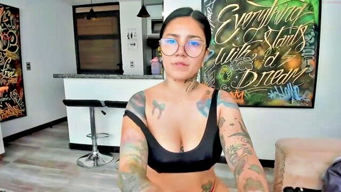 Tattooed trans performer Amy Connor in revealing black top, teasing cleavage on cam