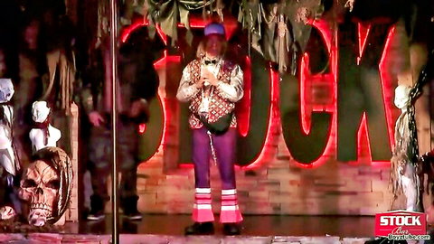 Halloween stripper in colorful floral vest and purple pants on stage at 2014 soiree