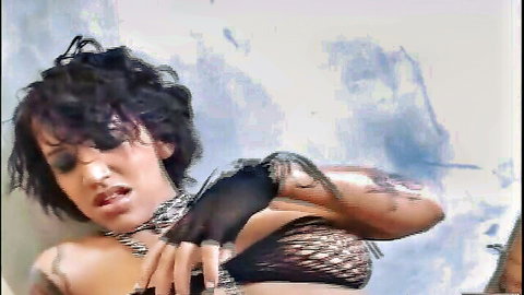 Busty tattooed woman in black lingerie and gloves posing seductively