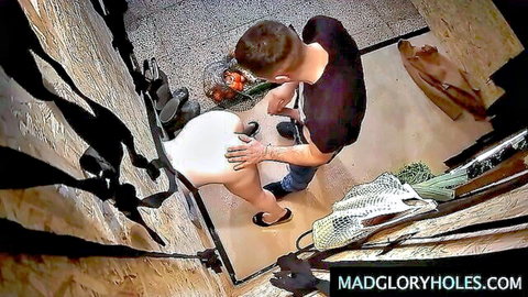 Young woman in glory hole booth gets touched by man through hole