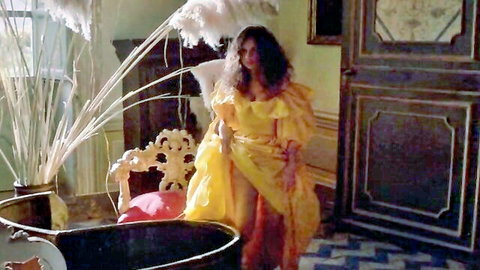 Curly-haired babe in frilly yellow gown teasing erotically in luxurious vintage room
