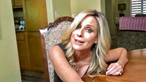 Blonde MILF smiling in black dress for POV handjob