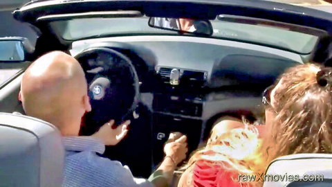 Busty brunette MILF shows massive tits cleavage to bald driver in BMW convertible
