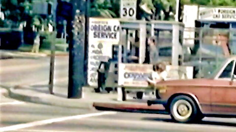 Vintage street scene at foreign car service bus stop with red 70s car and people nearby