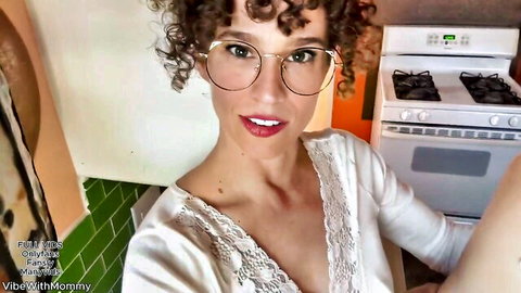 Curly-haired stepmom in glasses teases in low-cut silky robe