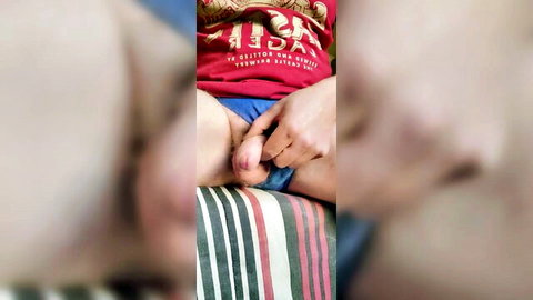 Amateur guy pulls down shorts to expose penis on bed