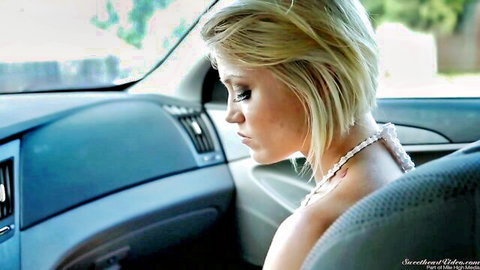 Blonde babe with cleavage in car seat wearing pearl necklace