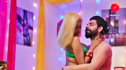 Blonde babe in green bikini passionately embraced by shirtless bearded man in hot Hindi web series