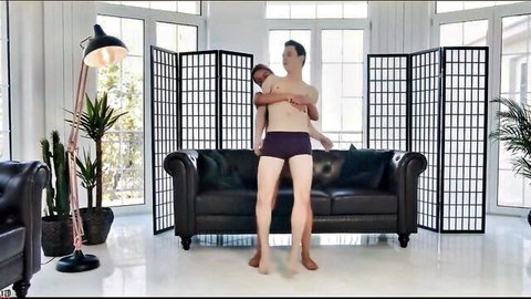 Two shirtless Asian men in tight purple briefs intimately embracing and lifting in luxurious room