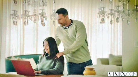 Vixen couple tease: man stands behind seated woman on laptop, intimate shoulder touch