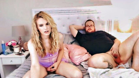 Blonde T-Girl in lingerie with her man's exposed huge cock on bed
