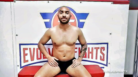 Oliver Davis shirtless muscular pose in wrestling shorts Evolve Fights