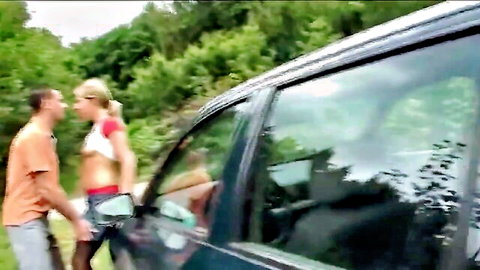 Blonde teen in crop top and shorts embraces guy outdoors by car