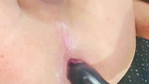Amateur woman teases black dildo with glossy pink lips closeup