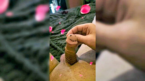 Carmen holds smiling penis dildo amid rose petals in playful solo scene