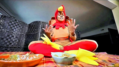 Black MILF in sexy turkey costume sitting cross-legged, big ass tease