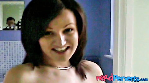 Topless brunette babe with big tits smiles with coke on nose in bathroom, man reflected in mirror