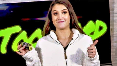Kenzie Page smiles with thumbs up holding green drink in white jacket