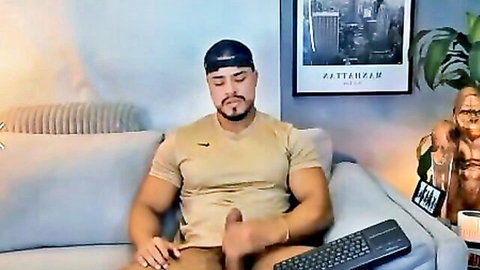 Muscular Latino man in tank top and cap, webcam solo tease with bulge