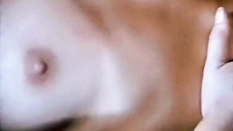 Hand pinching erect pink nipple on pale white woman's medium tit closeup
