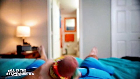 Stepmom in tight jeans on bed, gripping hard cock for intense handjob release