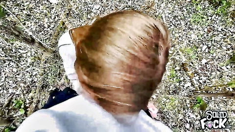 Blonde woman in white top walking through forest outdoors