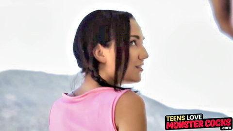 Smiling brunette teen in pink tank top with braids, outdoor profile view