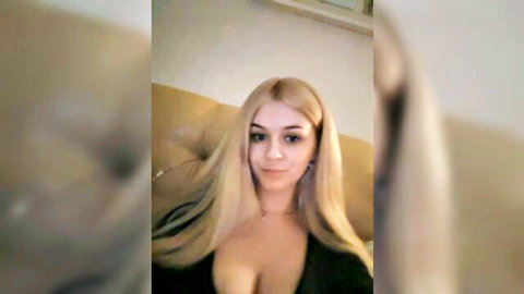 Sherry Dream blonde bombshell in low-cut black dress teasing cleavage