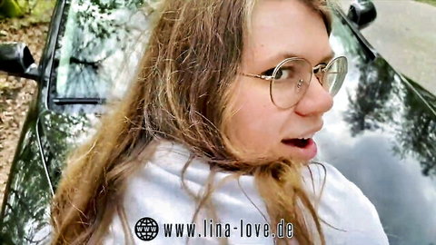 Lina Love blonde in glasses and white top, surprised outdoors by car at parking lot