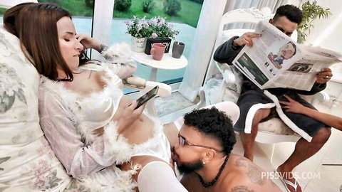 Pregnant woman in sheer feathered lingerie lounges with two BBC men, one hand groping her thigh