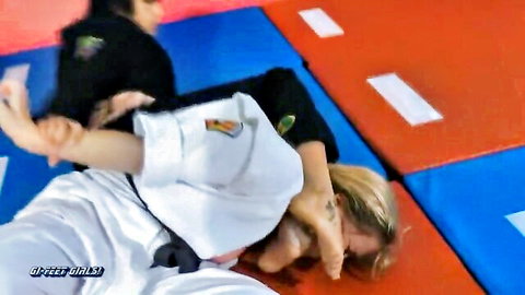 Japanese instructor demonstrates grappling hold on blonde babe in gi