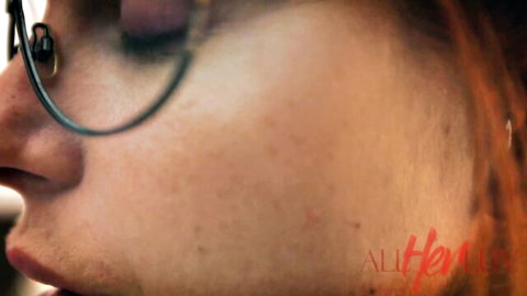 Close-up profile of sexy redhead with glasses and dreads from AllHer lesbian porn