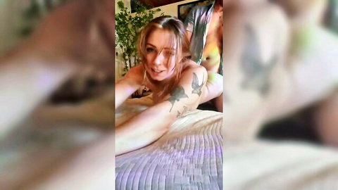 Ivory Fox redhead with bird tattoo posing nude on bed, smiling seductively