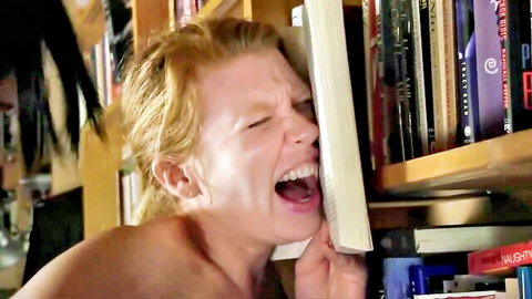 Redhead woman nude and screaming in ecstasy against book, topless solo tease