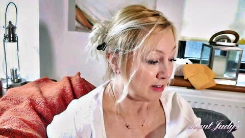 Mature blonde Aunt Judy smiling in white blouse, over 50 solo tease